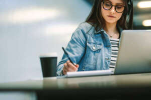 Stock student writing in book